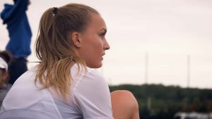 Emilie Girard, chaussant ses pointes d'athlétisme, concentrée avant une séance d'entrainement