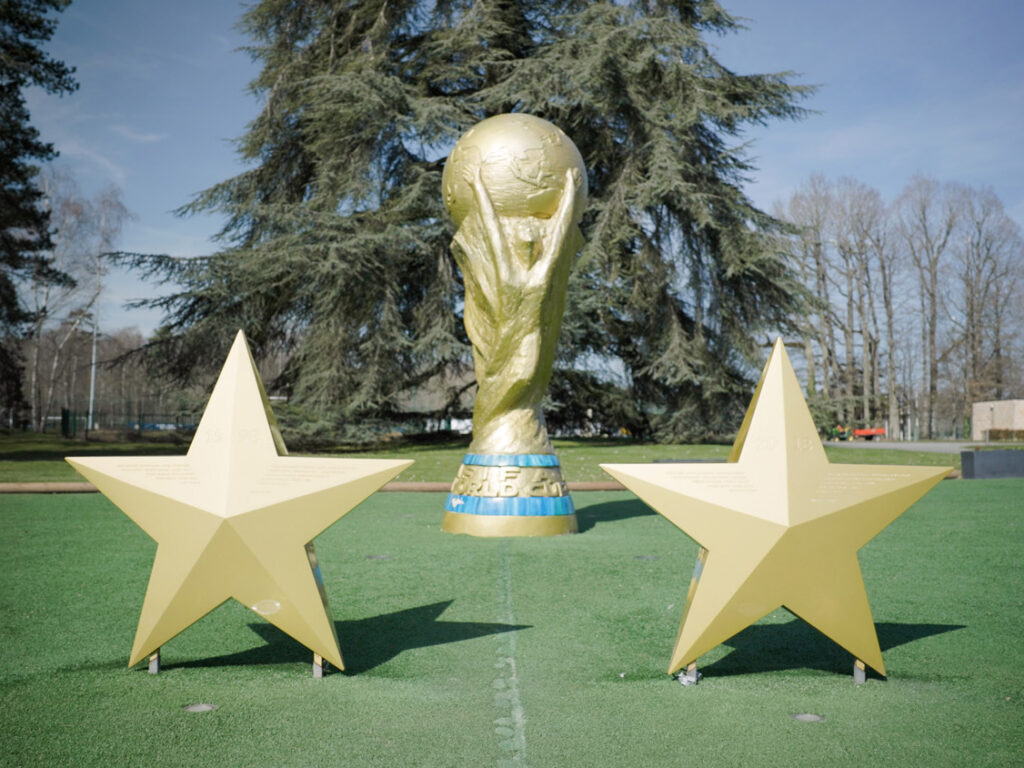 Photo de la statue du trophée de la Coupe du Monde de Football exposée à Clairefontaine, avec deux étoiles dorées
