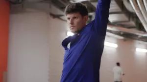 Plan moyen rapproché sur le buste de Benjamin Robert alors qu'il s'étire sur le stade d'échauffement de l'Arena Stade Couvert de Liévin, avant son 800m au Meeting de Liévin.