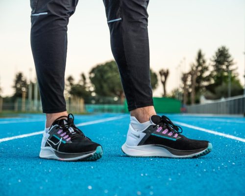 Paire de chaussure Nike Zoom Pegasus 38 portées au pieds de Benjamin Robert, sur une piste d'athlétisme en tartan bleu.